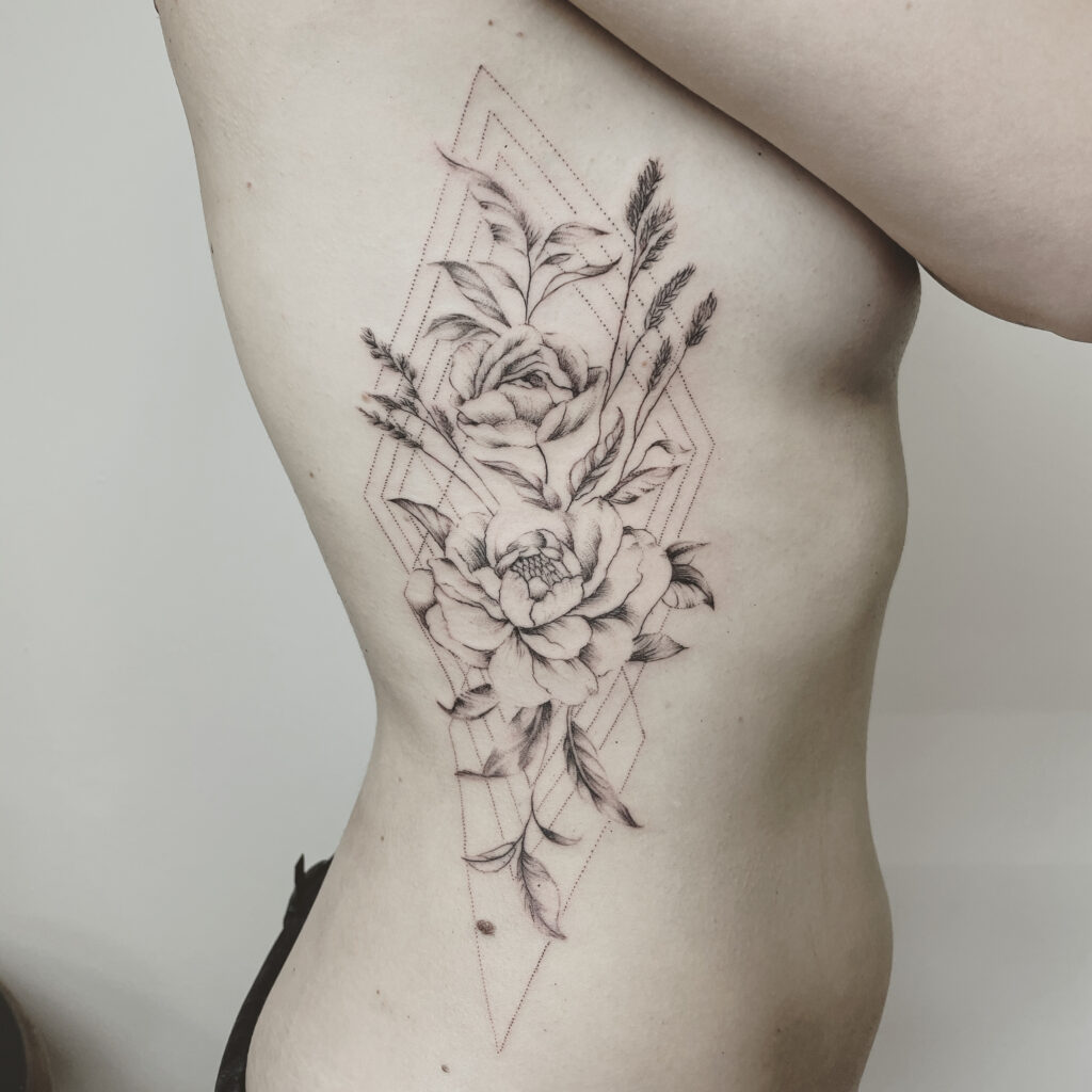 finelines tattoo zürich filigrane Blumen Rippen Frau Weiblich