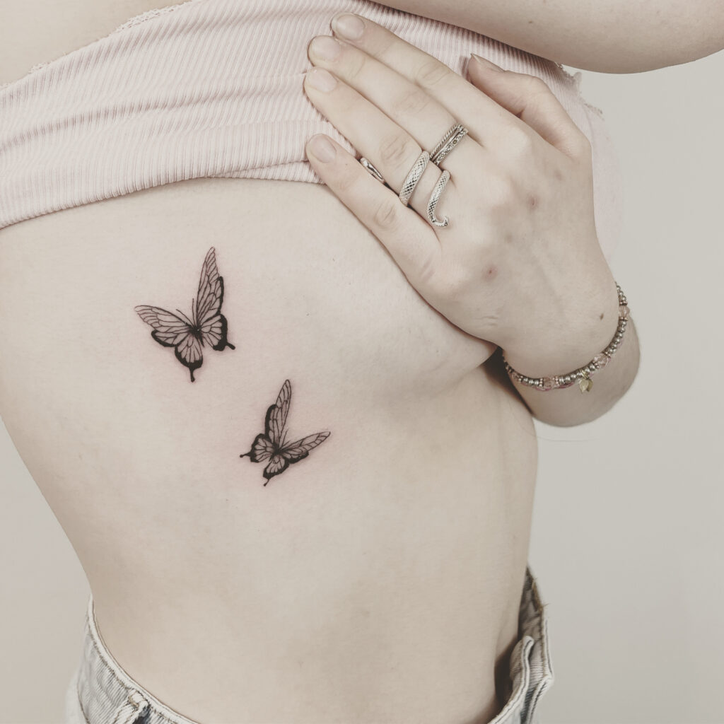 two flying butterfly tattoos in fineline style