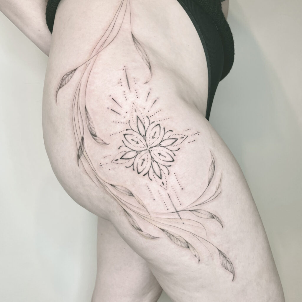 floral and geometric Tattoo on the hips of a woman, leaves and branches accentuate the tattooed person's natural curves to their advantage