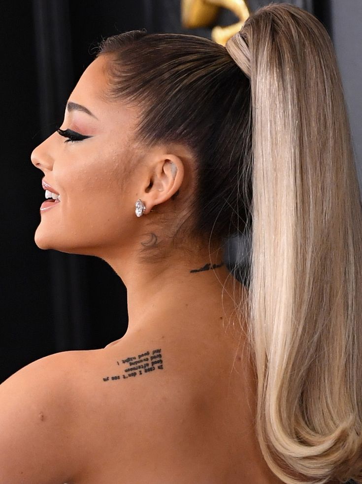 ariana grandes unreadable script tattoo on the back, zu klein gestochene script wird unlesbar mit die zeit, warum ist ein zu klein script tattoo keine gute idee, wie sieht ein schriftzug tattoo nach ein paar jahren