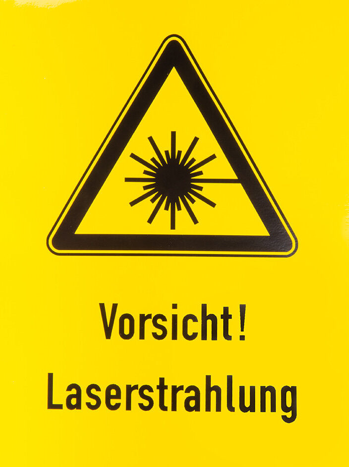 laser warnschild bild gelb und schwarz, ein schwarzer deieck auf gelbe hintergrung mit ein zeichnen von laserstrahlung in der mitte, unter der schild kann man vorsicht! lasereinstrahlung lesen