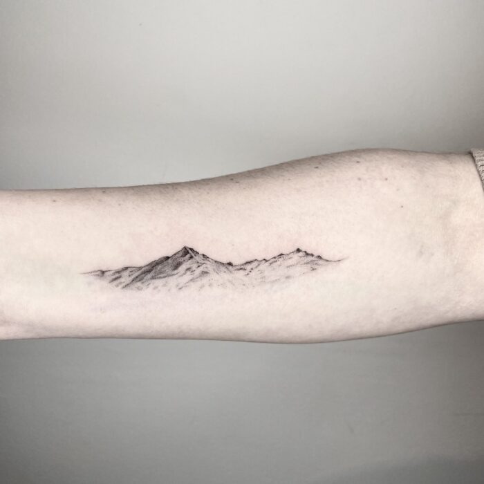 microrealistisches Tattoo von einem Berg, fineline tattoo von bergen