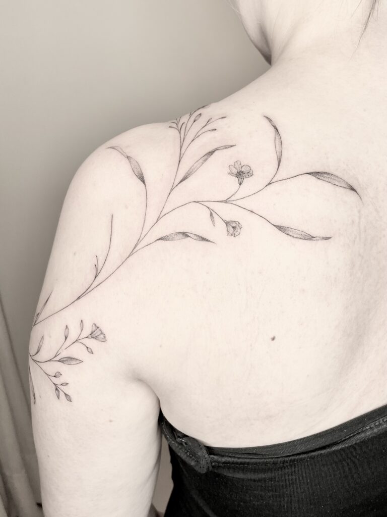 dünne linien tattoo, floral tattoo, freehand tattoo, tattoo auf die haut direkt gezeichnet, vergissmeinnicht tattoo in fineline stil auf der shulter und um den arm, delikate blüte Tattoo, elegante ranke tattoo am Arm, dünne blätter Tattoo, fineline Tattoo Zürich