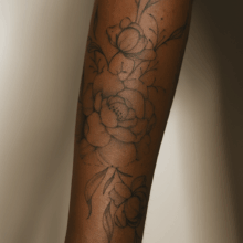 Feines Fineline-Tattoo einer Blume auf mittel- bis dunkelbrauner Haut – gestochen von Anef, Fineline-Spezialistin bei Amulett Tattoo Zürich