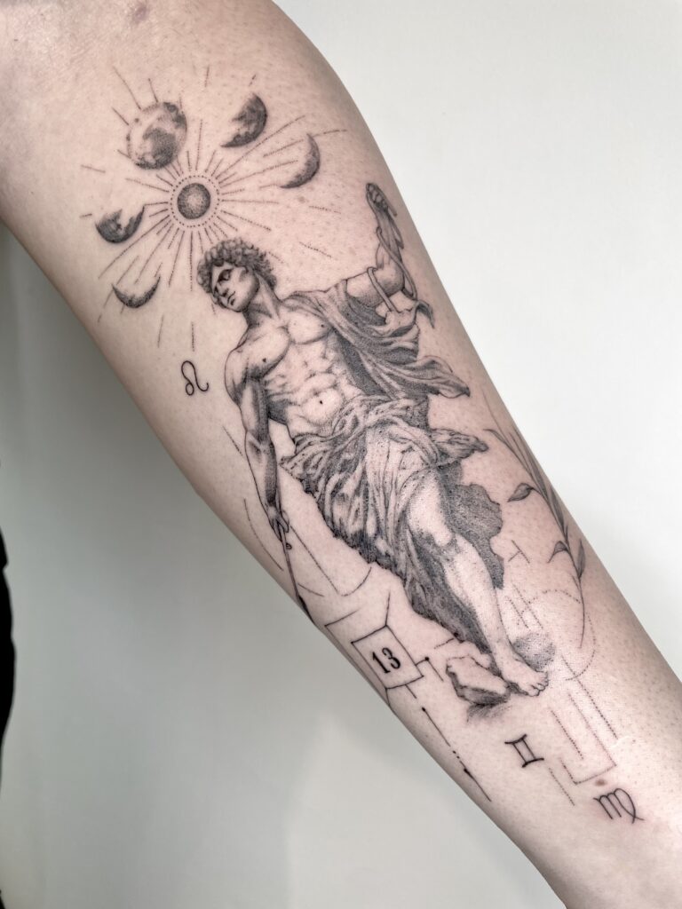 Appollo statue , antik greece statue tattoo, microrealistisch stil, komposition mit veschiedene persönliche elementsauf ein unterarm. Amulett Tattoo fineline expert zürich , microrealism